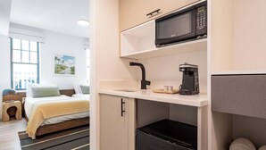 A compact kitchenette with a microwave, coffee maker, and a small refrigerator.