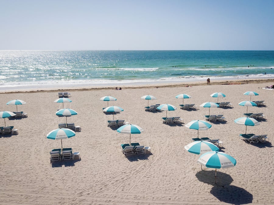 Vlak bij het strand, wit zand, ligstoelen aan het strand, strandlakens
