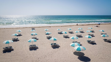 Una playa cerca, arena blanca, sillas reclinables de playa. Casa Sofi