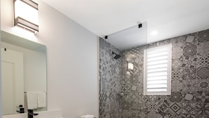 A bathroom with a white sink, a toilet, and a shower area.