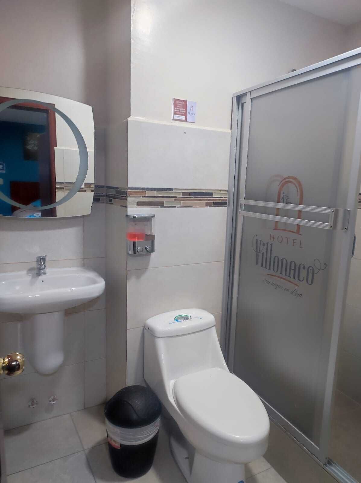 A bathroom with a sink, toilet, and a glass shower enclosure.