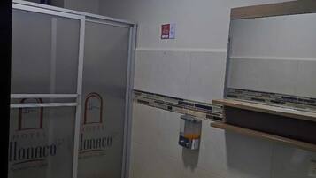 Baño de hotel con inodoro, lavamanos y ducha.