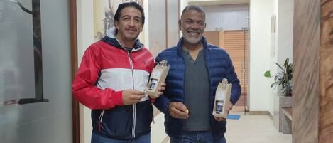 Two people standing in a hallway holding small packages.