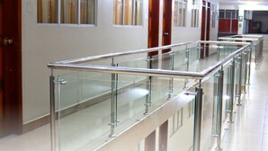 A long, modern corridor with glass railings and doors on either side. - Hotel Villonaco (Loja)