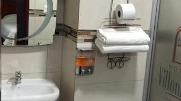 Une salle de bain avec un lavabo, des toilettes et un miroir.