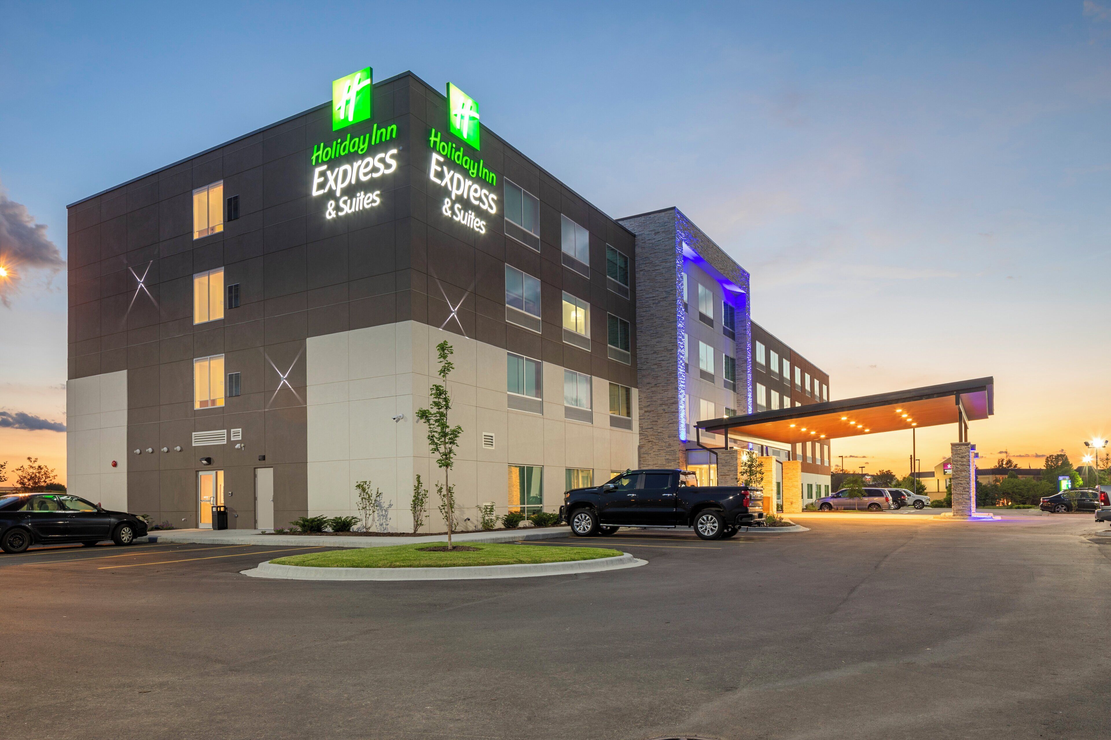 Un hôtel Holiday Inn Express & Suites au design moderne, doté d’un parking couvert et d’une entrée agrémentée d’un aménagement paysager.