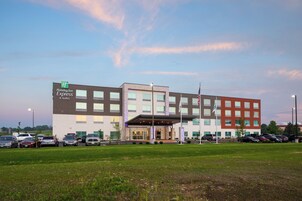 Un hotel Holiday Inn Express & Suites con un estacionamiento al frente.