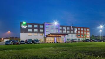 A Holiday Inn Express & Suites hotel with a parking lot and a grassy area in front.