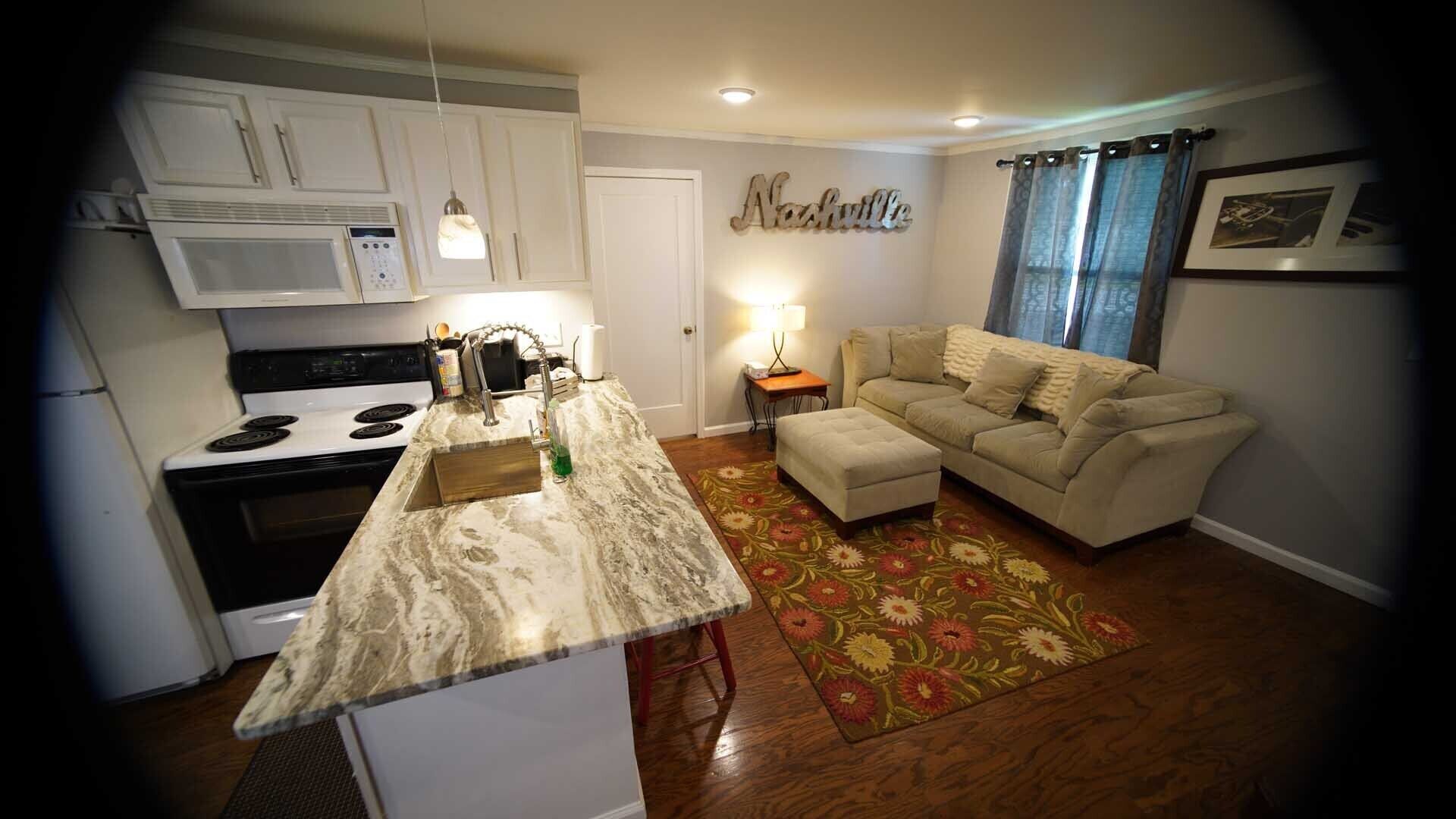 A compact living space with a kitchen, a sofa, and a coffee table.