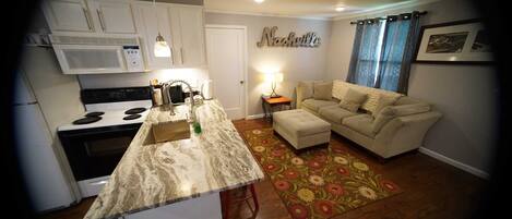 A compact living space with a kitchen, a sofa, and a coffee table.