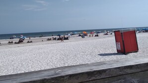 Una spiaggia con una veranda in legno in primo piano.