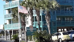 Un edificio a più piani con facciata color verde acqua e un'insegna che riporta la scritta 