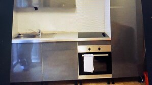 Una cocina con encimera de acero inoxidable, un lavabo y un horno empotrado.