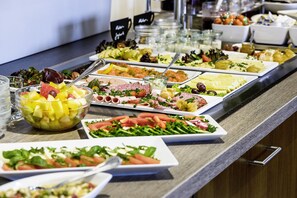 A buffet with various food options including salads, fruits, and meats. - Montana Landhotel Gummersbach Nord (Marienheide)