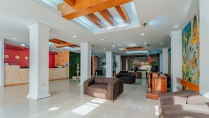 A spacious lobby with a reception desk, two sofas, and a coffee table. - Hotel Maya Yucatán (Mérida)
