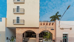A building with a beige facade, a stone archway entrance, and a sign reading "MAYA YUCATAN". - Hotel Maya Yucatán (Mérida)