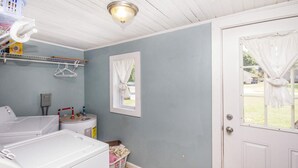 A laundry room with two washing machines, a drying rack, and a utility room with a water heater. - 2 Bedroom 1 Bath Cottage (Knoxville)