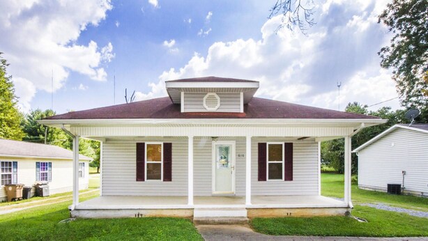 A single-story house with a front porch, a central door, and two windows on each side. - 2 Bedroom 1 Bath Cottage (Knoxville)