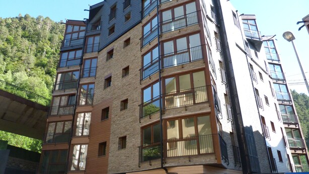 Un immeuble à plusieurs étages doté d’une architecture moderne, caractérisé par de grandes fenêtres et des balcons.