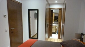Une chambre à coucher avec un lit, un miroir et une vue sur la salle de bain.