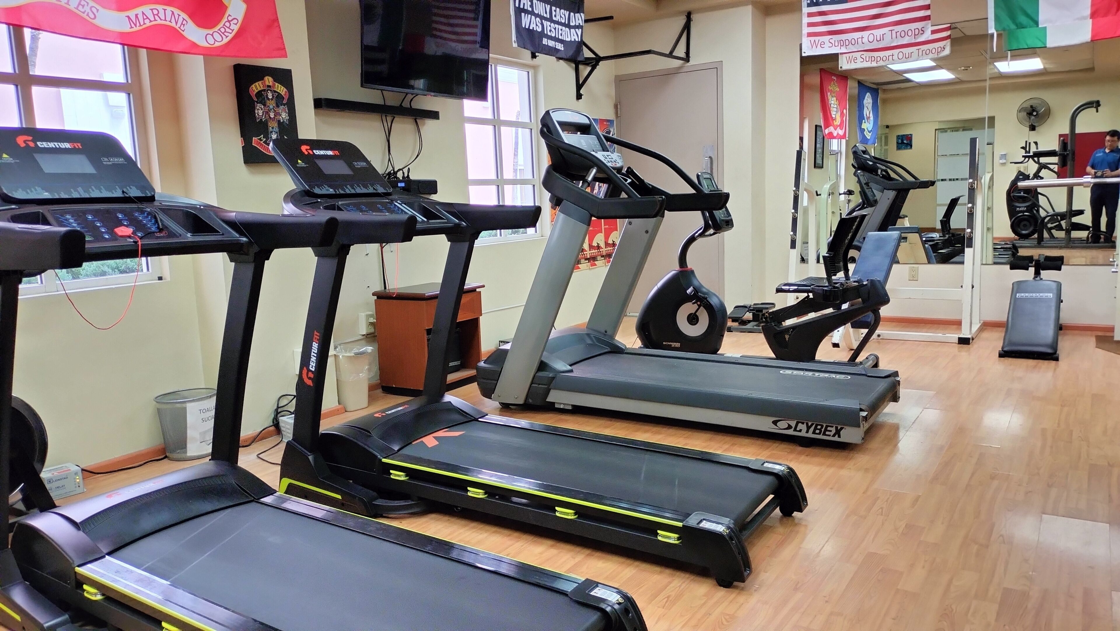 A gym with treadmills, a Cybex elliptical, and a weight bench.