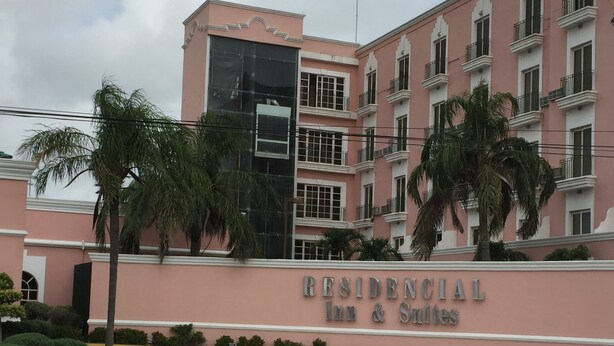 Un edificio rosa con un letrero que dice "RESIDENCIAL Inn & Suites".