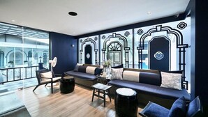 A modern lounge area with a sofa, chairs, and a coffee table. - Bhukitta Boutique Hotel - SHA Plus (PHUKET)
