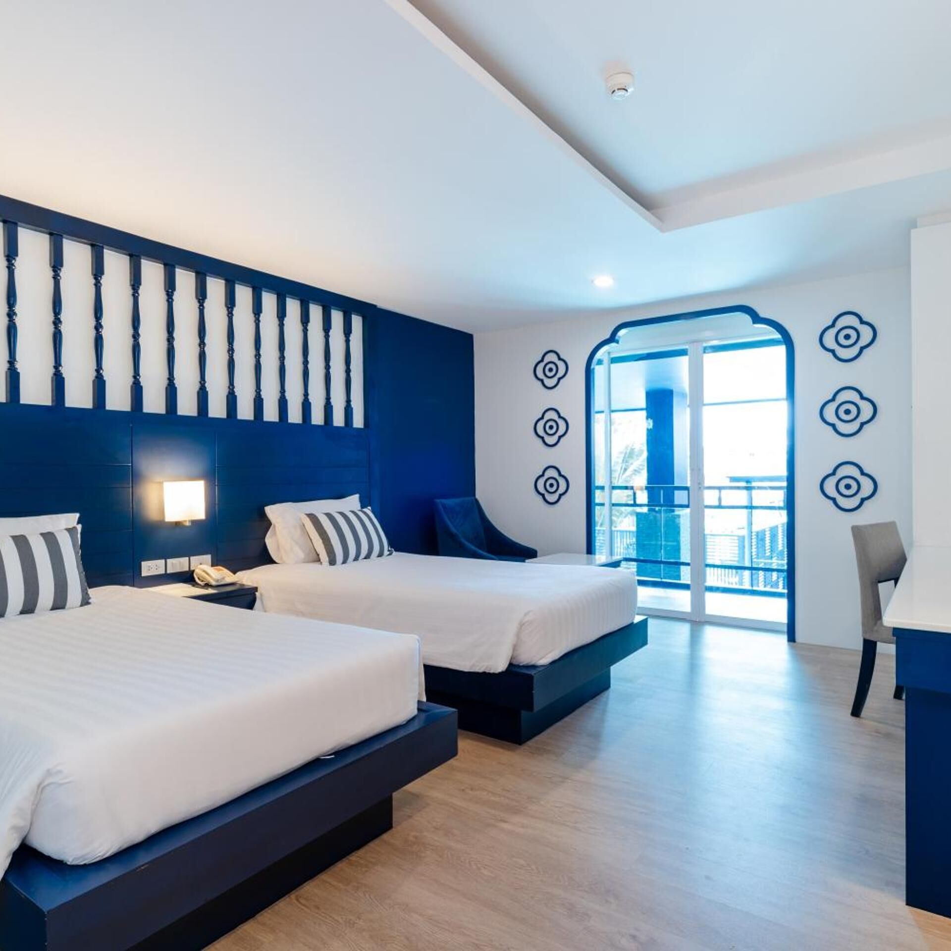 Habitación de hotel moderna con dos camas, un balcón y vistas.