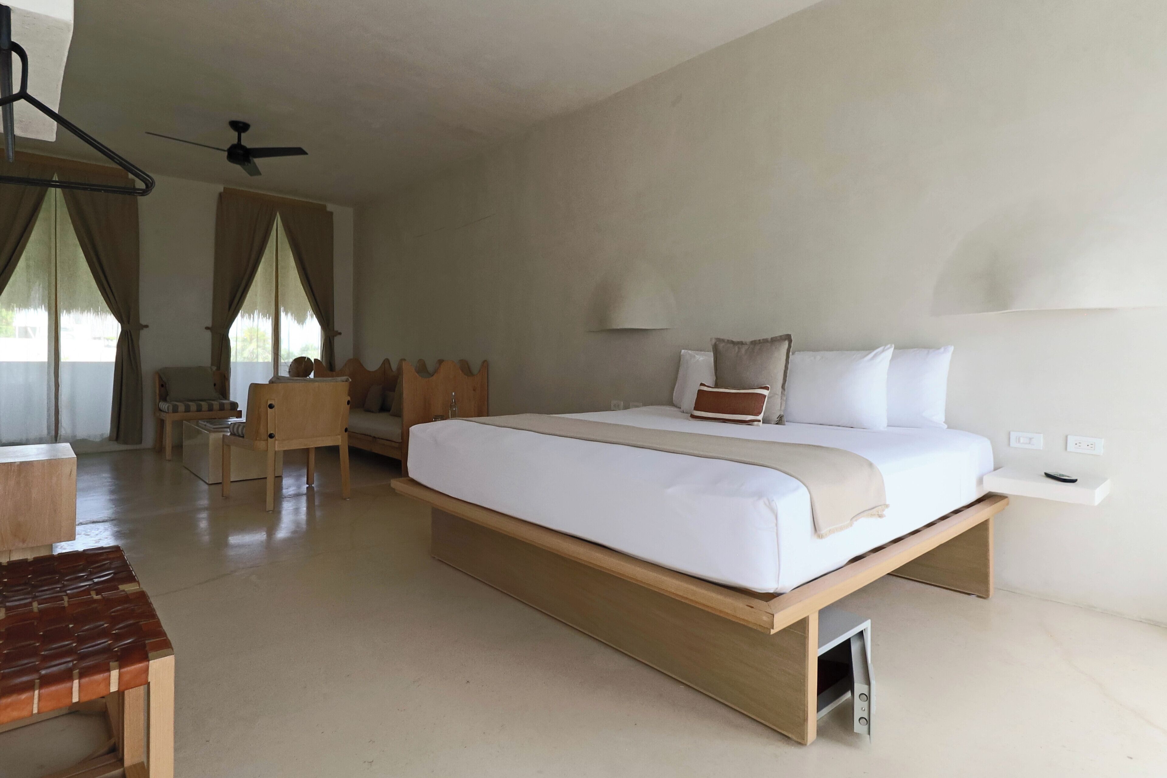 Un dormitorio moderno con una cama grande, un escritorio y una silla.