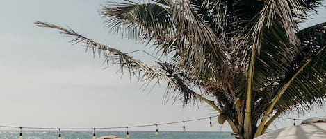 Een privéstrand, wit zand, gratis strandcabana's, parasols