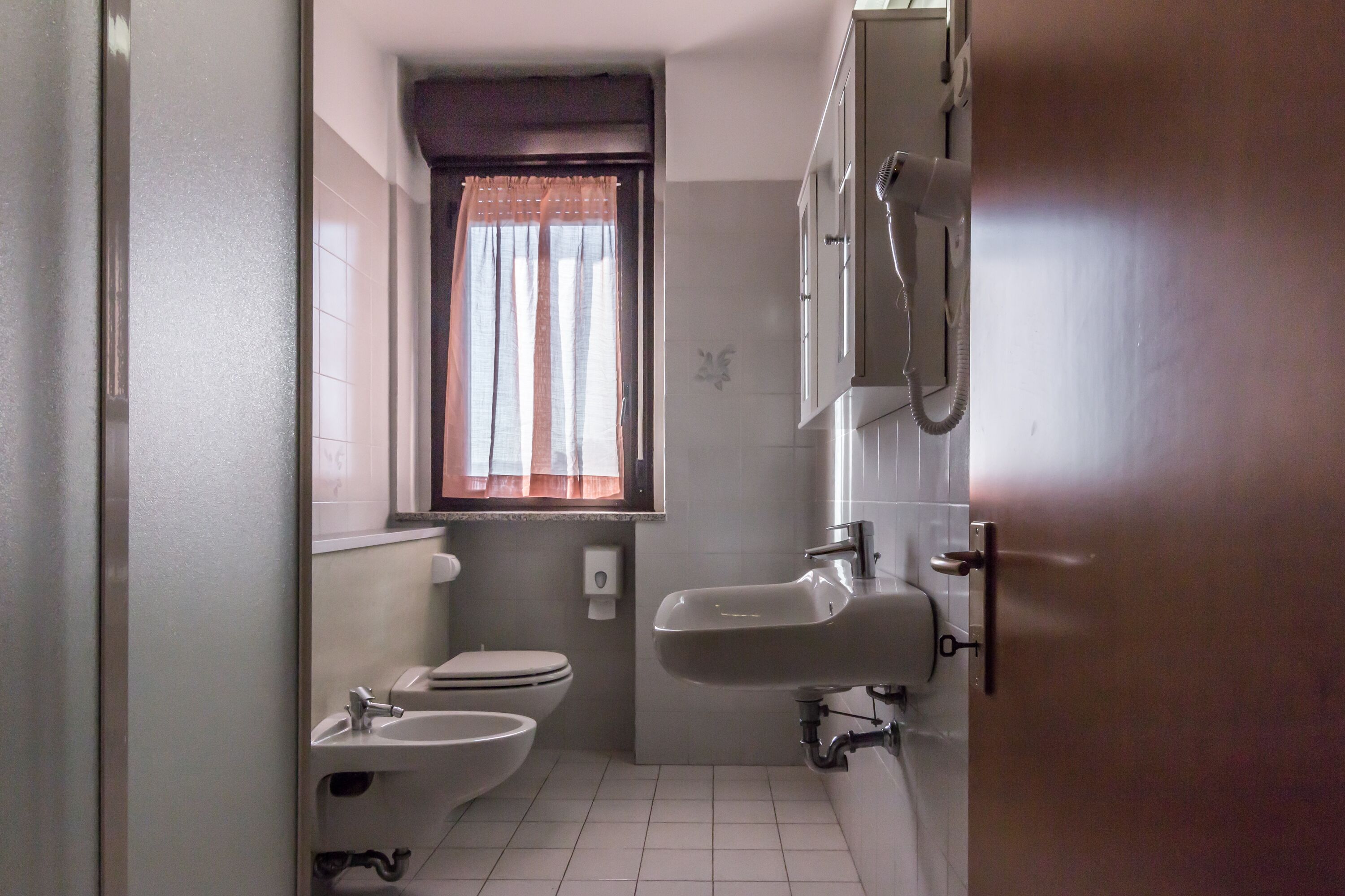 Une petite salle de bain comprenant des toilettes, un bidet et un lavabo.