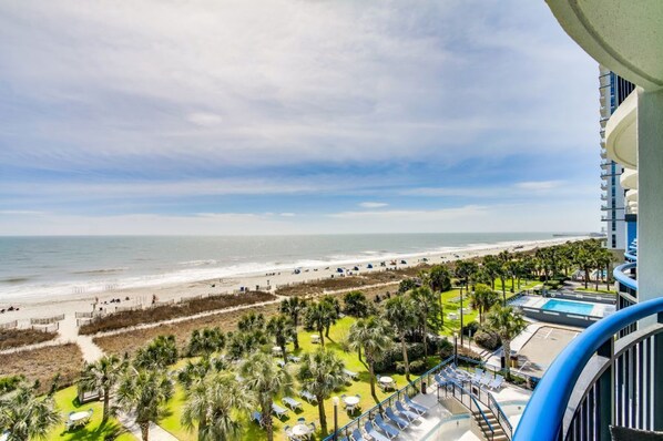 A resort with a beach view, a pool, and a balcony with sun loungers.