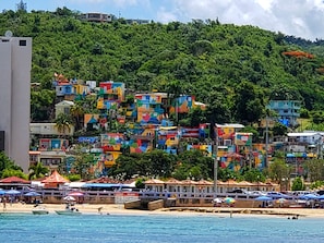 A coastal town with colorful buildings, a beach, and boats. - Ocean front studio aguadilla  (Aguadilla Pueblo)