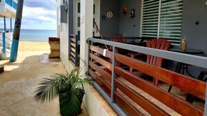 En restaurang vid stranden med uteservering, utsikt över havet och en krukväxt.