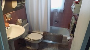 Ein Badezimmer mit Toilette, Waschbecken und Badewanne.