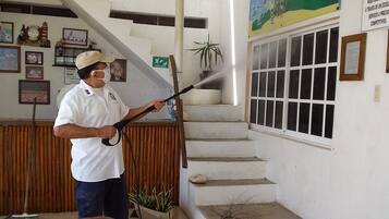 Una persona limpiando un ventanal con una hidrolavadora.