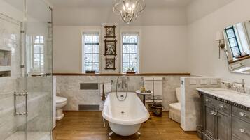 A spacious bathroom with a freestanding bathtub, a glass-enclosed shower, and a large vanity with a mirror.