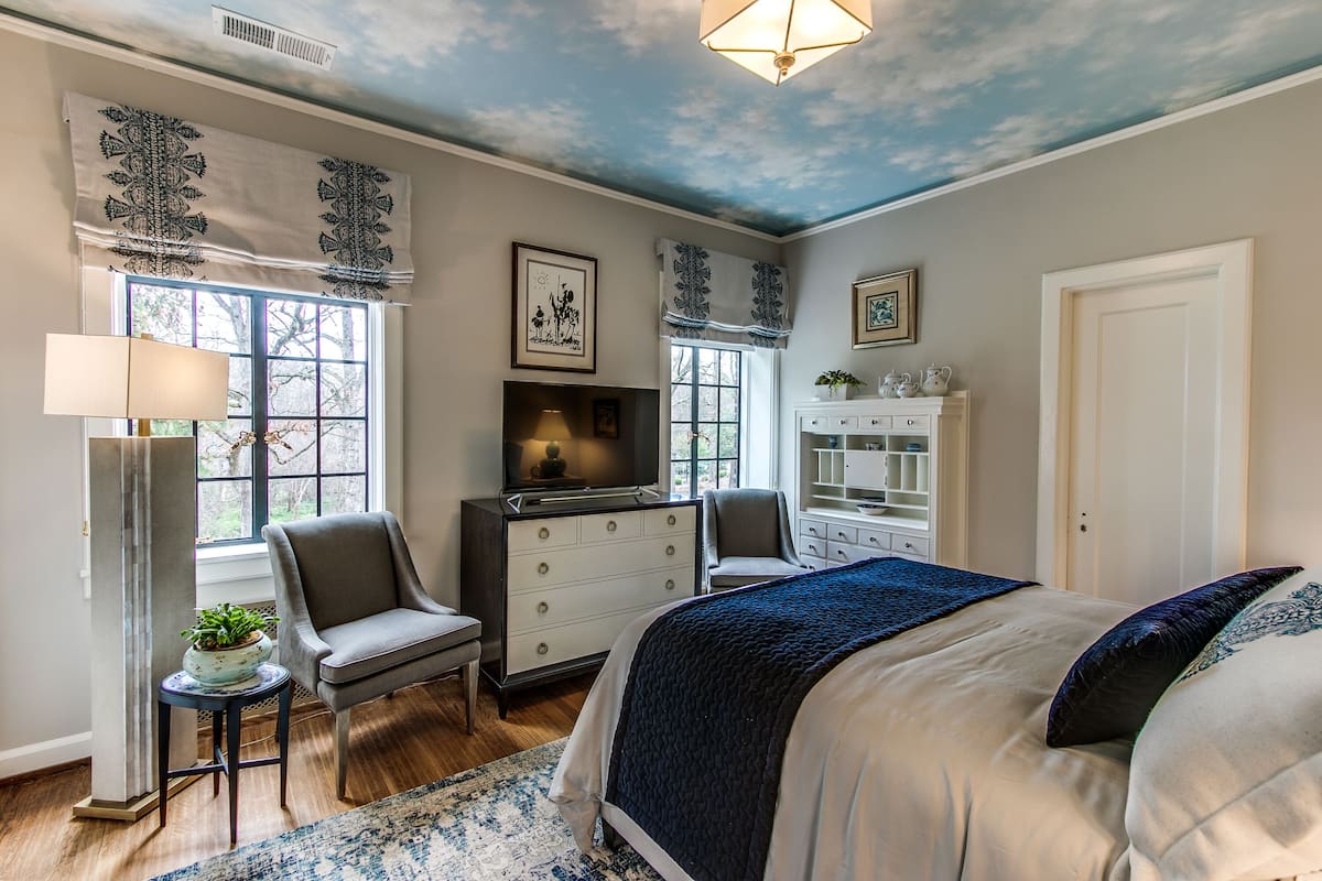 A bedroom with a bed, a dresser, a chair, a desk, and a window.