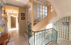 A staircase with a wooden railing and glass panels, leading to a landing with a door. - Homerez - Manor in Satillieu (Satillieu)