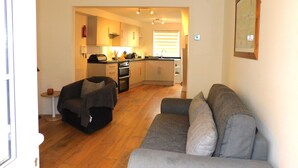 Ett kompakt bostadsutrymme med ett litet kök, en soffa och en matplats.