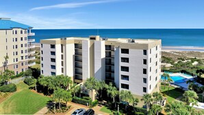 Un hotel de varios pisos con balcones con vista a la playa.