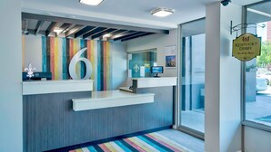 Un'area reception dal design moderno, con una grande decorazione con il numero '6', un monitor computer e una segnaletica che indica Kentucky Derby.