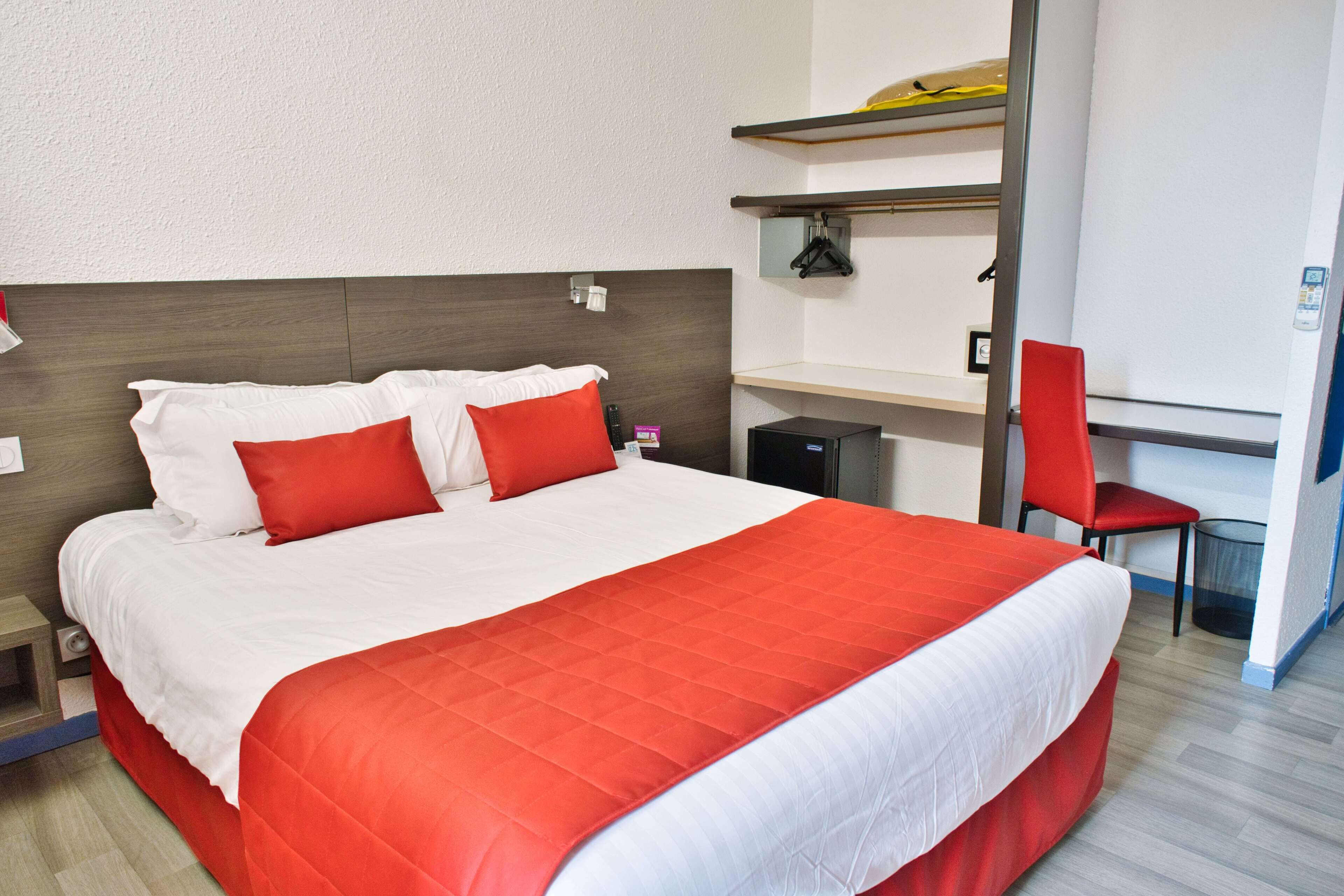 Una habitación de hotel con una cama grande, un escritorio y una silla.