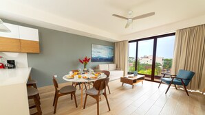 A modern living room with a dining area, a sofa, a coffee table, and a view of the city. - Tú Paraiso privado - Lahun suites Playa del Carmen  (Playa del Carmen)
