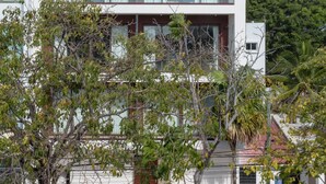 A modern two-story building with a flat roof, large windows, and a balcony. - Tú Paraiso privado - Lahun suites Playa del Carmen  (Playa del Carmen)