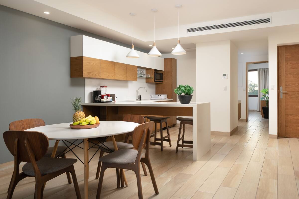 Una cocina moderna con armarios de madera, una isla central e iluminación colgante.