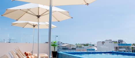 Piscine extérieure, parasols de plage, chaises longues