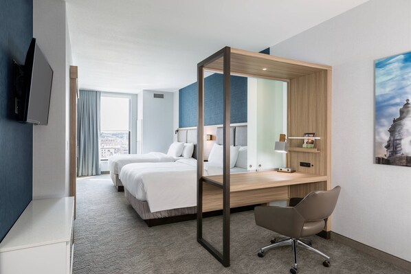 A modern hotel room with a large bed, a desk with a chair, a TV, and a city view. - SpringHill Suites by Marriott St. Paul Downtown (St. Paul)