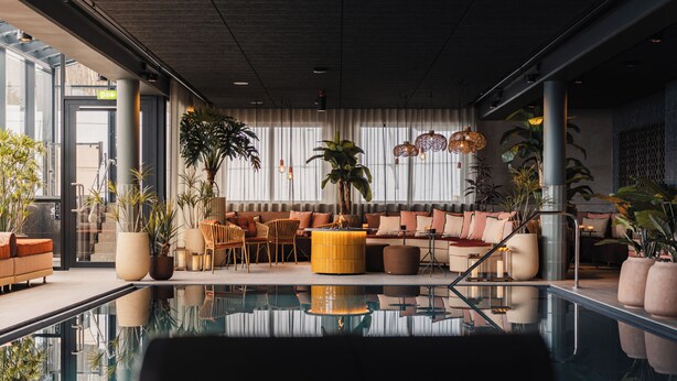 A modern lobby with a glass pool, seating areas, and large windows. - Lily Country Club (Ullensaker)