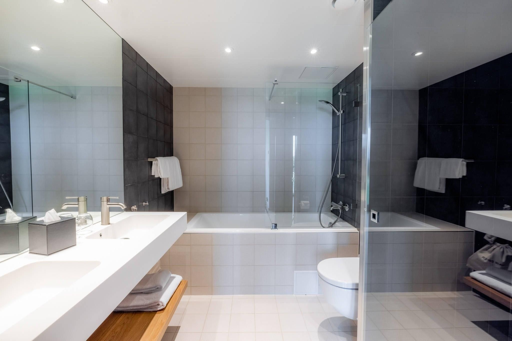 Un baño moderno con una bañera grande, una zona de ducha independiente y un lavabo con espejo.